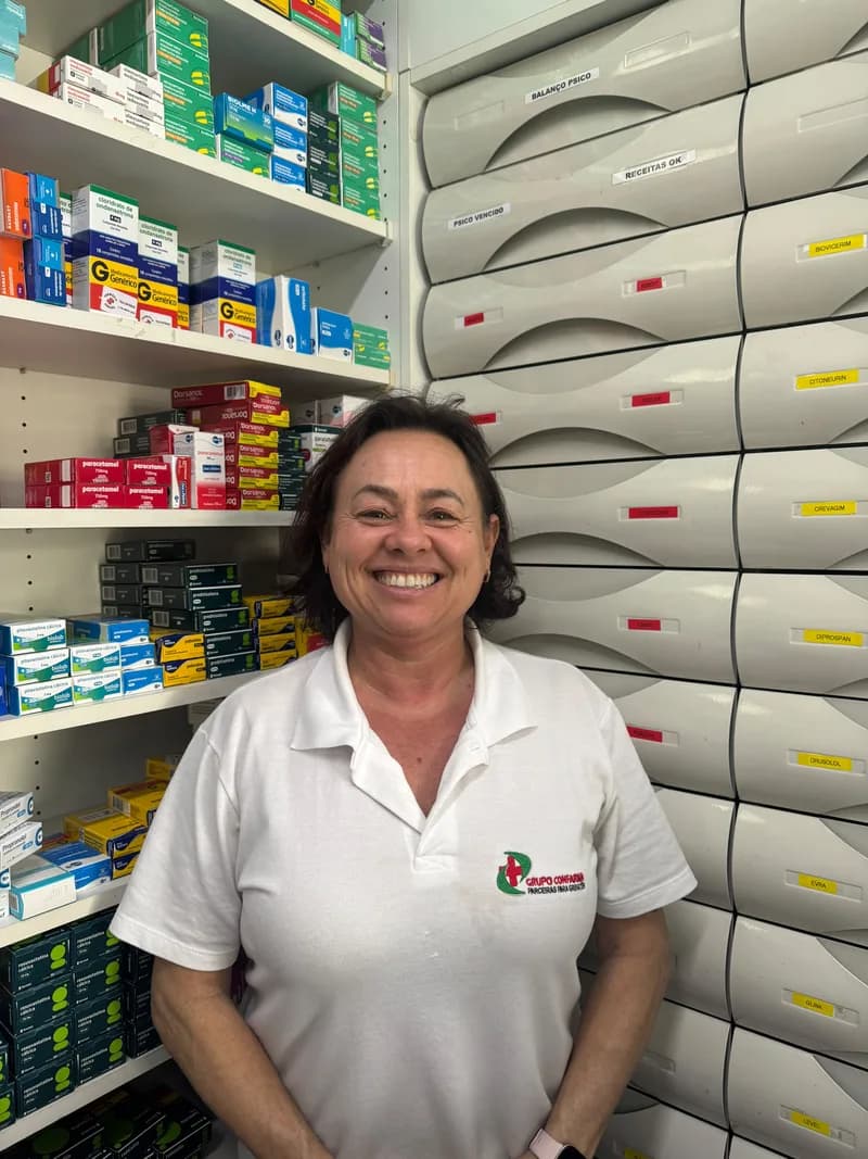 Fabíola, farmacêutica da Farmácia Abraão, sorrindo no balcão
